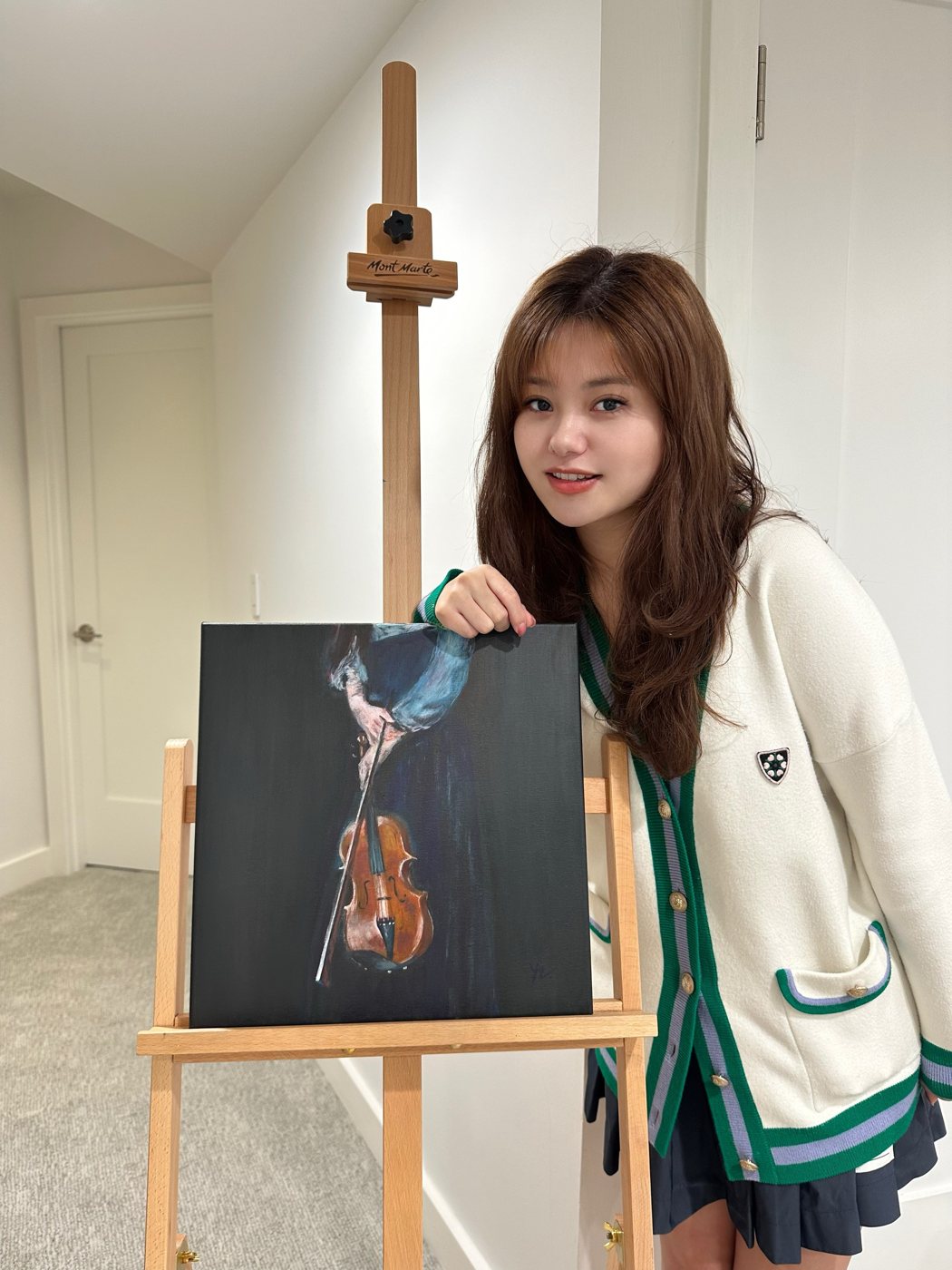 Yuanyi holding a painting of a violin
